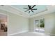 Bright bedroom with tray ceiling, fan, access to pool area and views of backyard at 13348 Rayburn Ln, Port Charlotte, FL 33981
