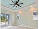 A serene bedroom with a modern ceiling fan, recessed lighting, and a sliding glass door at 13348 Rayburn Ln, Port Charlotte, FL 33981