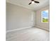 Clean bedroom featuring wood-look flooring, a window with a lush green view, and neutral paint at 13348 Rayburn Ln, Port Charlotte, FL 33981