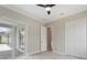 This bedroom features closet, light woodgrain flooring, sliding glass door to the lanai, and modern ceiling fan at 13348 Rayburn Ln, Port Charlotte, FL 33981
