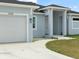 Inviting single-Gathering home featuring a bright, light-blue exterior with a white two-car garage and walkway at 13348 Rayburn Ln, Port Charlotte, FL 33981