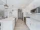 Modern kitchen featuring a large island, white cabinets, stainless steel appliances, and sleek pendant lighting at 13348 Rayburn Ln, Port Charlotte, FL 33981