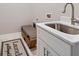 Convenient laundry room with a stainless steel sink, white cabinetry, and a stylish rug at 13348 Rayburn Ln, Port Charlotte, FL 33981