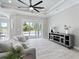 Bright living room boasts neutral walls, wood-look tile, and sliding glass doors with backyard and pool views at 13348 Rayburn Ln, Port Charlotte, FL 33981