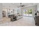 Spacious living room featuring wood-look tile flooring, a modern fan, and sliding glass doors to the lanai at 13348 Rayburn Ln, Port Charlotte, FL 33981