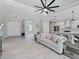 Open-concept living room featuring tray ceilings, wood-look tile floors and an island with bar stool seating at 13348 Rayburn Ln, Port Charlotte, FL 33981