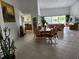 Open dining room with glass table and chairs, adjacent to kitchen and living room at 65 Ocean Dr, Punta Gorda, FL 33950