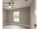 Bright bedroom with ceiling fan, large window, and wood-look floors at 820 Bowman Ter, Port Charlotte, FL 33953