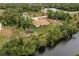 An aerial view showcasing a canal-front house with surrounding greenery at 820 Bowman Ter, Port Charlotte, FL 33953
