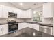 Modern kitchen with stainless steel appliances and granite countertops at 820 Bowman Ter, Port Charlotte, FL 33953