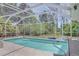 Screened-in pool area with surrounding trees at 7263 Sablon Rd, North Port, FL 34291