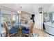 Dining area with glass table and four chairs, view of kitchen and living room at 6405 Kilohee Ct, North Port, FL 34287
