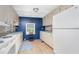 View of kitchen with white appliances and blue accent wall at 6405 Kilohee Ct, North Port, FL 34287