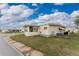 Single-wide manufactured home with a large window and AC unit at 6405 Kilohee Ct, North Port, FL 34287