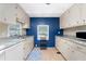 Full view of kitchen with white appliances and blue accent wall at 6405 Kilohee Ct, North Port, FL 34287