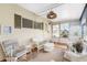 Cozy screened porch with white wicker furniture and a ceiling fan at 6405 Kilohee Ct, North Port, FL 34287