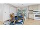 Glass dining table with four chairs, near kitchen and access to patio at 6405 Kilohee Ct, North Port, FL 34287