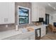 Modern kitchen with farmhouse sink, white cabinets and a view to the backyard at 11 Pinehurst Ct, Rotonda West, FL 33947