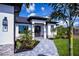 Welcoming entry with a stone walkway, lush landscaping, and double front doors at 11 Pinehurst Ct, Rotonda West, FL 33947