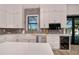 Modern kitchen with white cabinets, farmhouse sink, and stainless steel appliances at 11 Pinehurst Ct, Rotonda West, FL 33947