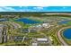 Aerial view of community with lake, golf course, tennis courts, and clubhouse at 15999 Grassland Ln # 3221, Punta Gorda, FL 33982