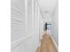 Long hallway with light wood floors and white louvered doors at 85 Vivante Blvd # 8534, Punta Gorda, FL 33950