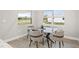 Bright dining area with glass table and four chairs, offering natural light and view at 10429 New Brittain St, Port Charlotte, FL 33981
