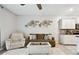 Living area with brown couch, white armchair, and access to the kitchen at 6516 Serenity Fall Ln, Sarasota, FL 34240