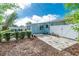 Backyard features a mix of pavers, lush greenery, and a well-maintained blue home exterior at 22062 Marshall Ave, Port Charlotte, FL 33952