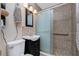 Bathroom with single sink vanity, updated lighting, glass shower and unique stone floor at 22062 Marshall Ave, Port Charlotte, FL 33952