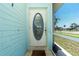 Charming front door with an oval glass insert and light blue frame, inviting entry to the home at 22062 Marshall Ave, Port Charlotte, FL 33952