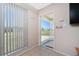 Living room featuring a large window and tile flooring, looking out onto the screened in entryway at 22062 Marshall Ave, Port Charlotte, FL 33952