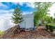 Backyard shed with mature landscaping including a small pine tree and bamboo accents for added privacy at 22062 Marshall Ave, Port Charlotte, FL 33952
