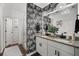 Elegant bathroom with granite countertops, double sinks, and stylish wallpaper at 43789 Cattleman Dr, Punta Gorda, FL 33982