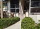 Condo building entrance with stairs and manicured landscaping at 1515 Forrest Nelson Blvd # E106, Port Charlotte, FL 33952