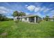 Home with a large backyard, screened patio, and mature landscaping at 27441 Natal Dr, Punta Gorda, FL 33983