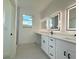 Elegant bathroom with double vanity and framed mirrors with windows at 26345 Trinilas Dr, Punta Gorda, FL 33983