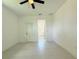 This is a spacious bedroom with tile flooring, a ceiling fan and a door at 26345 Trinilas Dr, Punta Gorda, FL 33983