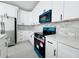 Modern kitchen with white cabinetry, stone backsplash, and stainless steel appliances, ready for cooking at 26345 Trinilas Dr, Punta Gorda, FL 33983