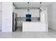 Modern kitchen featuring white cabinets, an island with pendant lighting, and stainless steel appliances at 26345 Trinilas Dr, Punta Gorda, FL 33983