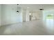 Bright, open living space with white walls, modern lighting, and tile flooring leading to the kitchen at 26345 Trinilas Dr, Punta Gorda, FL 33983