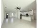 Bright, open living space with white walls, modern lighting, and tile flooring leading to the kitchen at 26345 Trinilas Dr, Punta Gorda, FL 33983