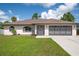 Single-story home with attached garage, front lawn, and landscaping at 2563 S San Mateo Dr, North Port, FL 34288