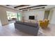 Living area with sliding doors to backyard, wood beams and light flooring at 28976 Gin Ln, Punta Gorda, FL 33982