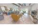 Open living room and kitchen with wood beams, light floors and access to covered patio at 28976 Gin Ln, Punta Gorda, FL 33982