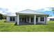 Modern home with a metal roof, covered patio, and spacious backyard at 28976 Gin Ln, Punta Gorda, FL 33982
