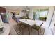 Dining room with marble table, green chairs and view into kitchen at 28992 Gin Ln, Punta Gorda, FL 33982