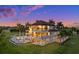 Stately home featuring multiple balconies, a pool, lush landscaping, and scenic views at dusk at 21321 Harborside Blvd, Port Charlotte, FL 33952