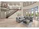 Bright living room features a soaring ceiling, large windows, iron-railed staircase, and elegant decor at 21321 Harborside Blvd, Port Charlotte, FL 33952
