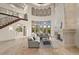 Living room with soaring ceiling, a marble fireplace, and expansive windows offering natural light and grand staircase at 21321 Harborside Blvd, Port Charlotte, FL 33952